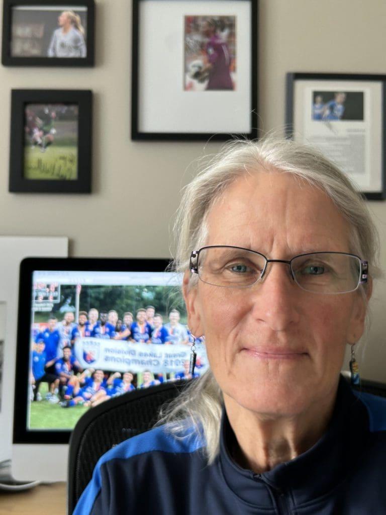 Person with glasses in office, computer and frames.